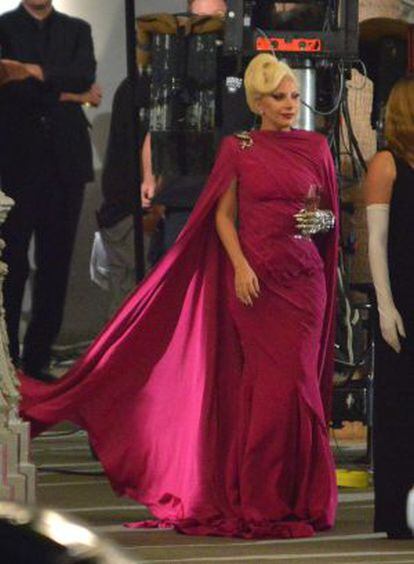Lady Gaga con su vestido rosa fucsia pasea por el set de rodaje. 