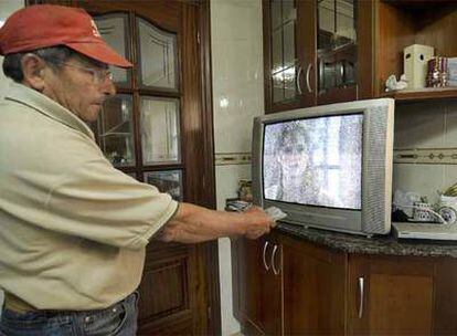 Un vecino del lugar de Castrelo, en Paradela, trata de sintonizar algún canal en la televisión de su casa.