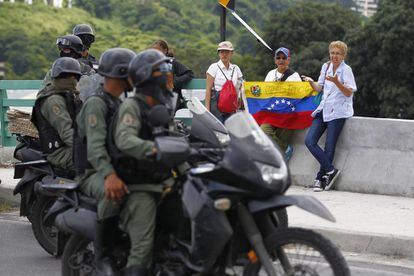 Opositores venezolanos con una bandera nacional en Caracas.