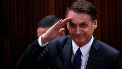 Bolsonaro saluda antes de recibir el diploma del Tribunal Electoral.