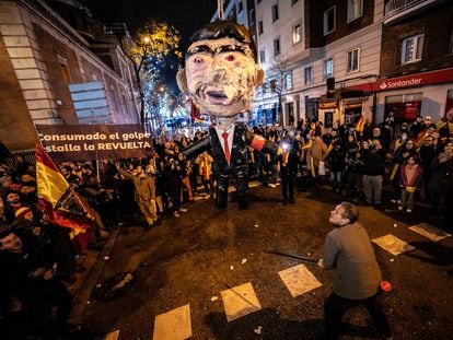 Un hombre se prepara para golpear un muñeco de Pedro Sánchez, la pasada Nochevieja cerca de la sede del PSOE en Madrid.