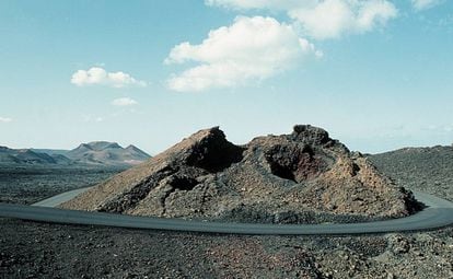 Carretera rodeando un cráter volcánico, en el Parque Nacional de Timanfaya, en la isla de Lanzarote, provincia de las Palmas de Gran Canaria (Canarias).