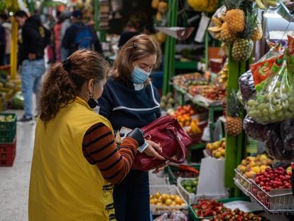 Personas compran frutas y verduras, en la plaza de mercado Paloquemao, en Bogotá, Colombia.