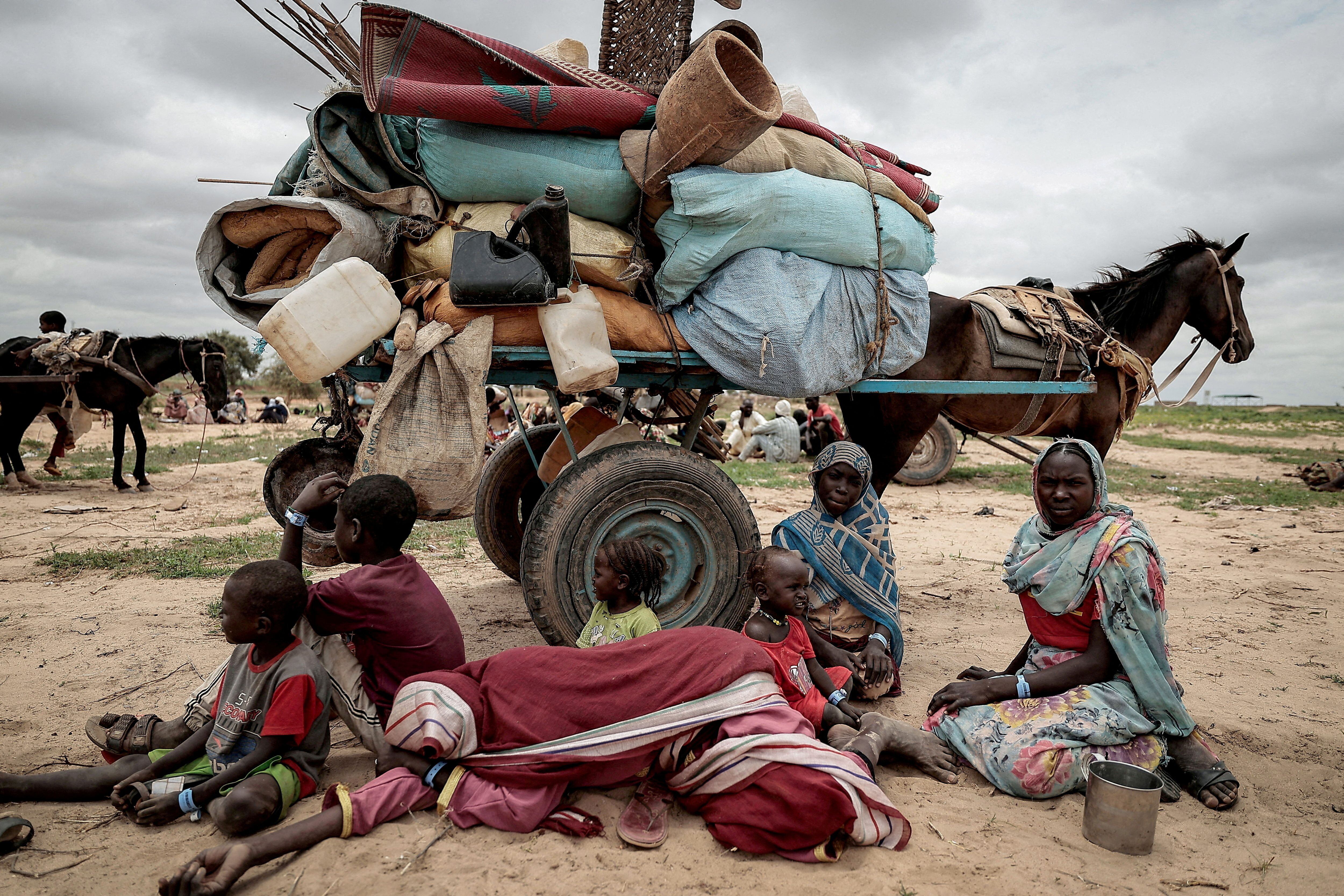 Una familia sudanesa que huyó del conflicto en Murnei, en la región sudanesa de Darfur, descansa junto a sus pertenencias al cruzar la frontera entre Sudán y Chad, en la localidad chadiana de Adre, el 26 de julio de 2023.