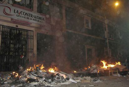 Manifestantes queman un coche policial frente a la sede de una oficina gubernamental en Puno, en la frontera con Bolivia
