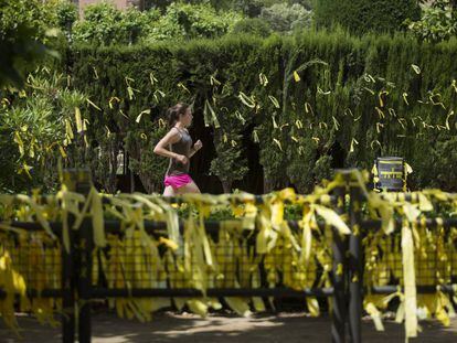 Una jove corre en una zona plena de llaços grocs, al parc de la Ciutadella. 
 