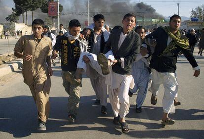 Un grupo de afganos lleva a uno de los heridos en el ataque