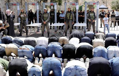 Varios hombres rezan este domingo frente a los detectores de metales instalados en la entrada a la Explanada de las Mezquitas.