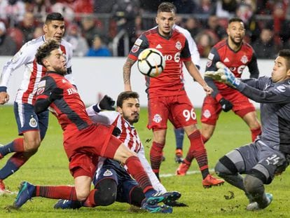 El portero Jiménez de Chivas bloquea un tiro de Osorio de Toronto.