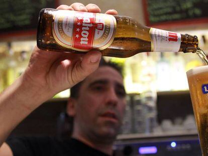 Un empleado de un bar sirve una cerveza.
