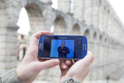 Un usuario de Áppside observa un vídeo en lengua de signos mientras visita el acueducto de Segovia.