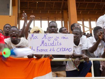 Partidarios de los golpistas muestran un cartel en el que se lee "Yo, Níger, maldigo a Francia y a la Cedeao", el domingo pasado durante una concentración en un estadio de Niamey.