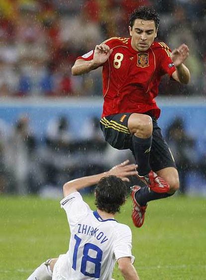 Xavi salta ante Zhirkov en el partido entre España y Rusia de la primera fase.