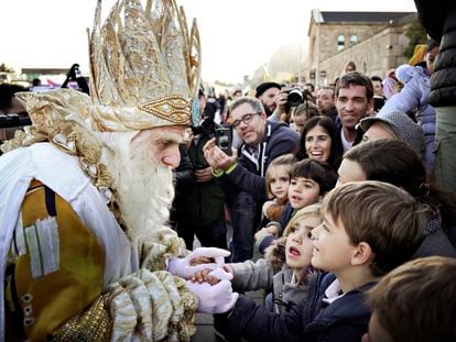 El Rey Melchor saluda a los niños que han acudido a recibirle en el puerto de Barcelona antes de la cabalgata.