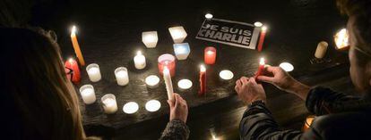 Varias personas prenden velas en honor a los asesinados.