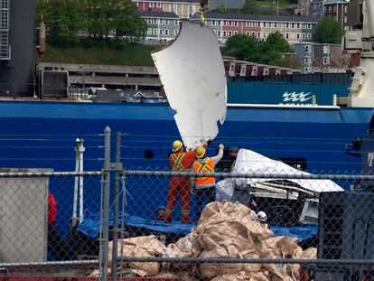 Dos operarios descargan fragmentos del 'Titan', el miércoles en el puerto de San Juan de Terranova (Canadá).