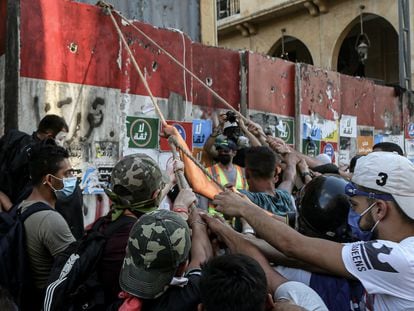 10 August 2020, Lebanon, Beirut: Anti-government activists try to put down the concrete block which is closing the road that leads to the house of the parliament during clashes with riot police in Beirut's downtown. The Lebanese government resigned following the massive Beirut port explosion of 04 August which killed at least 158 people, wounded 6000 and displaced some 250,000 to 300,000. Photo: Marwan Naamani/dpa
10/08/2020 ONLY FOR USE IN SPAIN