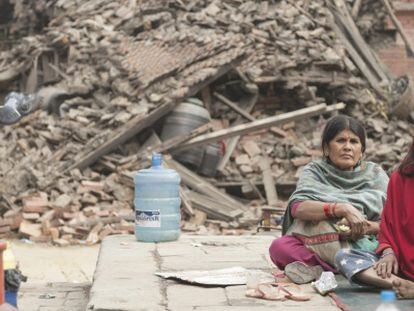 Dues dones, aquest diumenge, davant un edfici destruït a la regió de Katmandú.