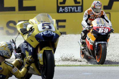 Nicky Hayden aprovecha la caída de Colin Edwars (izquierda) para liderar la carrera de MotoGP en el Gran Premio de Holanda.