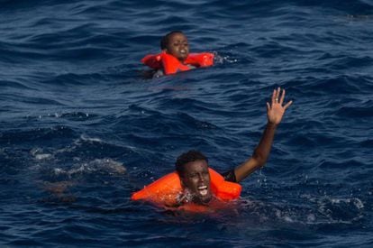 Dos náufragos subsaharianos piden auxilio tras zozobrar su embarcación cerca de la costa de Libia. / C. MCGRATH (GETTY IMAGES)