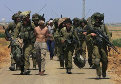 Soldados israelíes escoltan a un grupo de palestinos detenidos, cerca de Kissufim