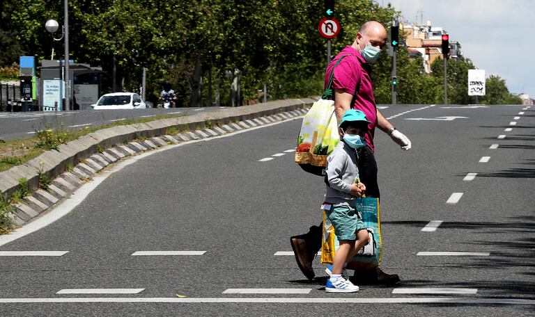 Un niño acompañado de un adulto por el centro de Madrid, este sábado.
