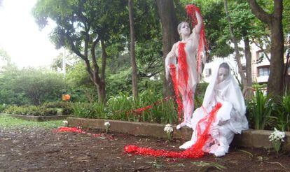 Dos actores de Alas de mariposa recrean La Pietá como esculturas humanas en una intervención en el Parque de la Bailarina de Medellín.