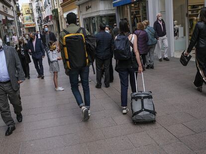 Unos turistas pasean por el centro de Sevilla.