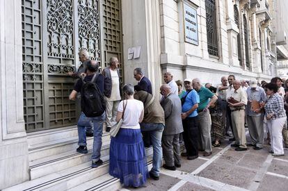 Clientes esperando para entrar en una sucursal bancaria en Atenas. Los bancos griegos reabrieron el lunes por la mañana, después de tres semanas de cierre.