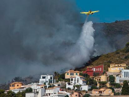 Una avioneta realiza una descarga de agua sobre las llamas que avanzan hacia una zona de viviendas en la Atzubia.