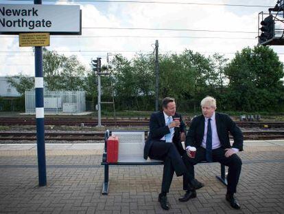 El primer ministro brit&aacute;nico, David Cameron (izquierda) y el alcalde de Londres, Boris Johnson, esperan el tren tras un mitin en Newark.