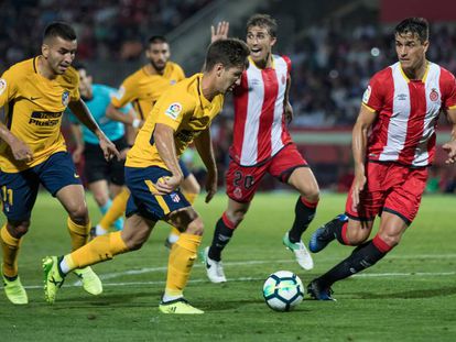 Vietto trata de zafarse de un defensa del Girona, con Correa a su espalda.