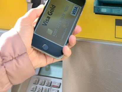 Una usuaria acerca su tel&eacute;fono para hacer una transacci&oacute;n.
