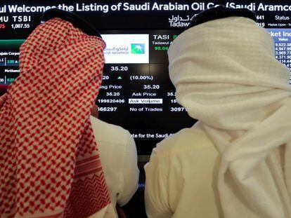 Dos inversores miran una pantalla en la Bolsa de Riad.