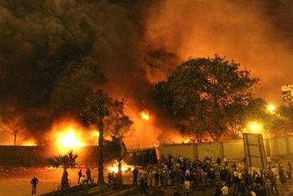 Grupos de manifestantes se concentran ante la sede del gubernamental Partido Nacional Democrático, envuelta en llamas, en El Cairo.