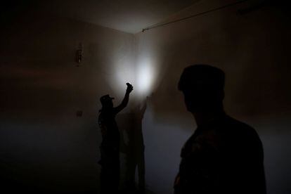 Una cámara colgada en la celda donde permanecían los prisioneros estaba conectada con la oficina de los guardias. En la imagen, miembros del ejército iraquí inspeccionan los cables de un sistema de vigilancia instalado en una de las habitaciones utilzadas como celda por el Estado Islámico.