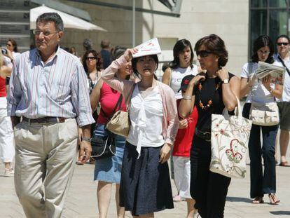 Varios turistas, a la salida del Museo Guggenheim de Bilbao.