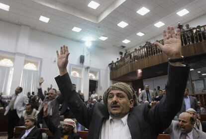 Miembros del parlamento yemen&iacute; alzan sus manos para votar a favor de la ley que da inmunidad al presidente Saleh. 