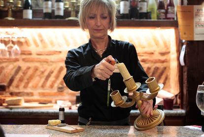 Una camarera enciende el pincho Velada Perfecta en el restauarnte Los Zagales (Valladolid). Esta elaboración es pollo de corral en pepitoria con manzana, pistacho y cobertura de chocolate blanco.
