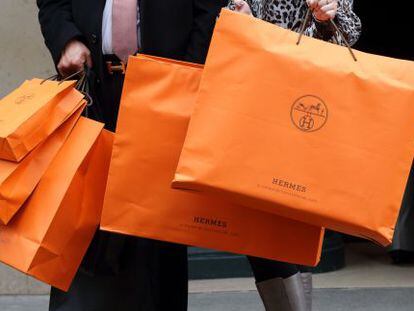 Una pareja con bolsas de una tienda de Hermès en París.