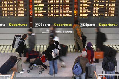 Pasajeros frente a los paneles de información del aeropuerto Charles de Gaulle.