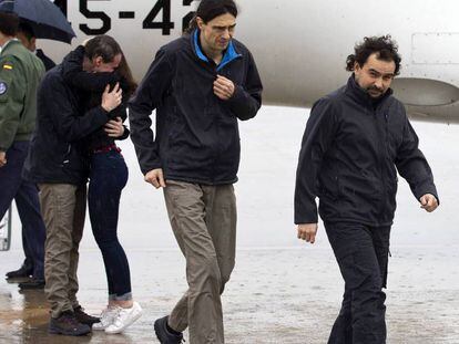 Ángel Sastre (derecha), José Manuel López (centro) y Antonio Pampliega (izquierda, abrazando a un familiar), a su llegada esta mañana a la base aérea de Torrejón de Ardoz (Madrid).