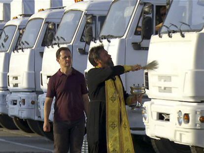 Un miembro del clero de la Iglesia Ortodoxa rusa bendice a los camiones el 12 de agosto en las afueras de Moscú / Foto: AP | Vídeo: Reuters Live!