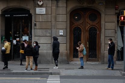 Decenas de personas hacen cola este miércoles para someterse a pruebas de antígenos o PCR para la detección de la covid-19 en un laboratorio de Barcelona, este miércoles.
