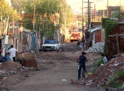 Unos niños juegan entre escombros y basura, en una zona de chabolas de Buenos Aires.