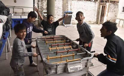 Los niños juegan al metegol (futbolín) en la escuela de la Virgen del Milagro.