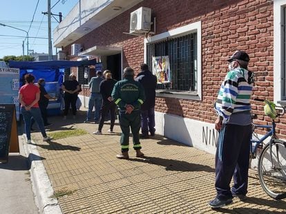 Vecinos de Ensenada, en las afueras de Buenos Aires, hacen fila frente a un puesto de ventas de pastas instalado en el club Alumni.