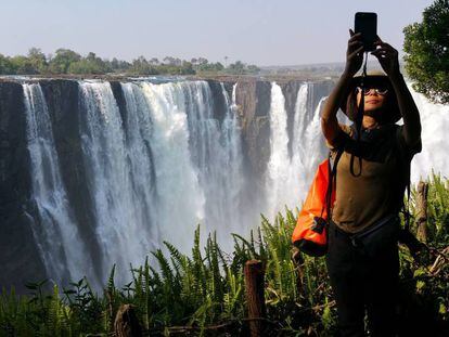 Una turista se fotografía en el lado zimbabués de las cataratas Victoria, formadas por el río Zambeze.