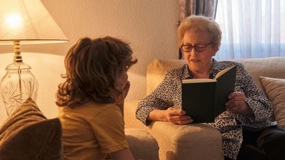 Una abuela le lee un libro a su nieto.