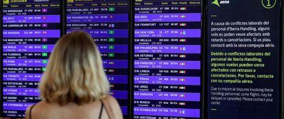 En la foto, una pasajera mira el panel de vuelos en el aeropuerto de Barcelona. 